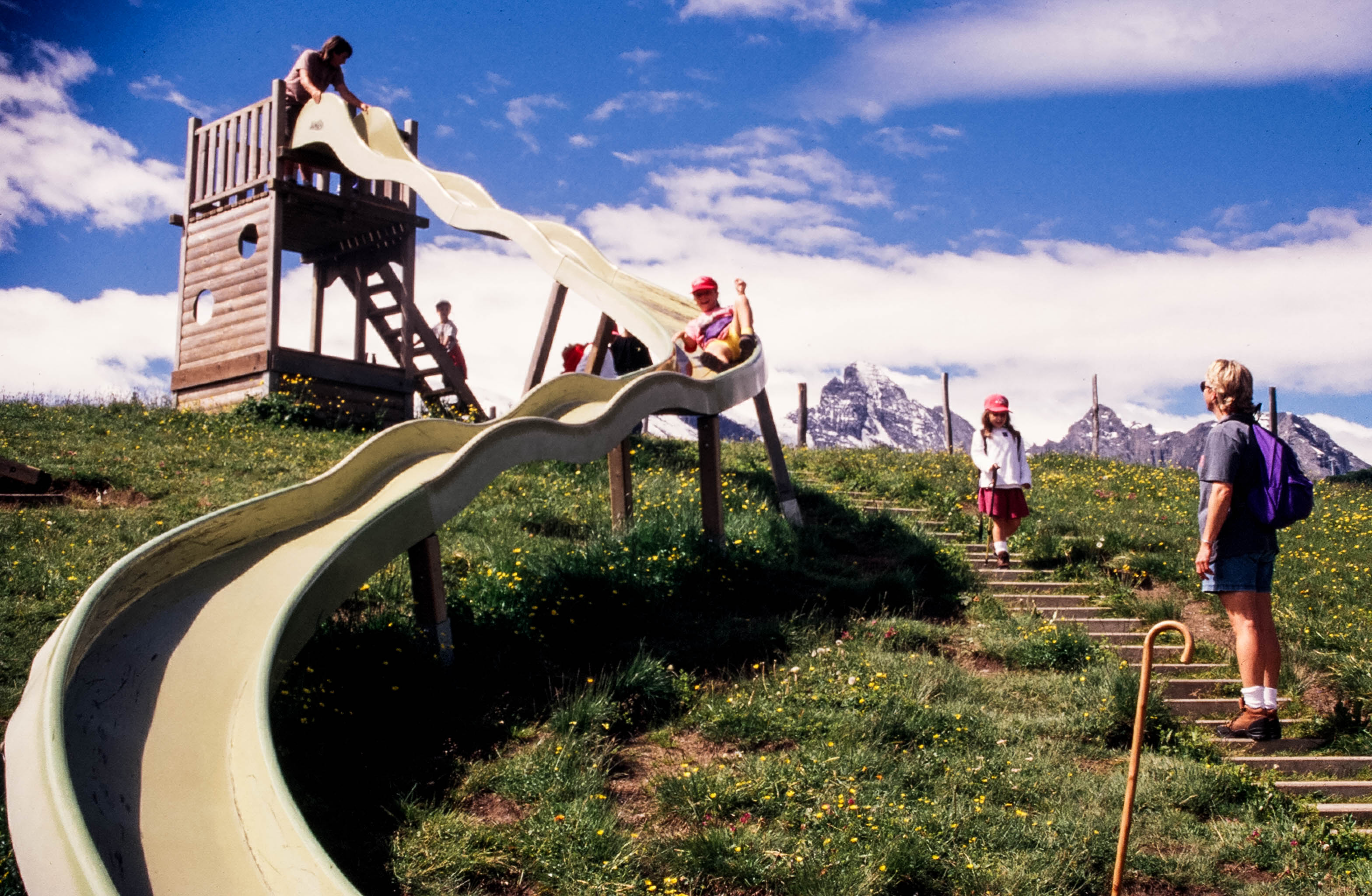 Kids playing on a playground in Switzerland, showing how traveling families pass down inherited wanderlust (image © Peter Boynton).