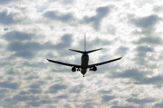 Plane flying through clouds, offering travel adventures and air travel stories of the memorable kind. (Image © Artem Tryhub/iStock.)