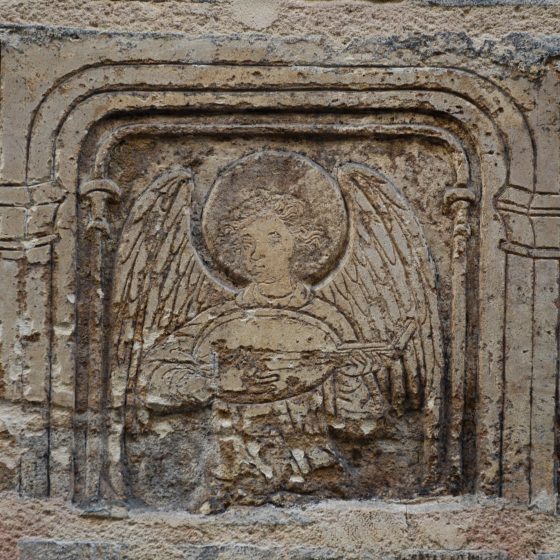 Stone carving of an angel playing a mandolin, one of the angels of Paris who serve as a cultural symbol. (Image © Rosemary Flannery.)