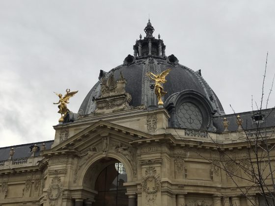 Two gold creatures atop the Petit Palais in Paris, some of the angels of Paris that serve as a cultural symbol. (Image © Meredith Mullins.)