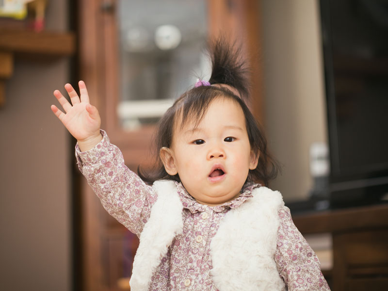 A baby waving shows that saying hello is fundamental across cultures. (Image © M-image/iStock)