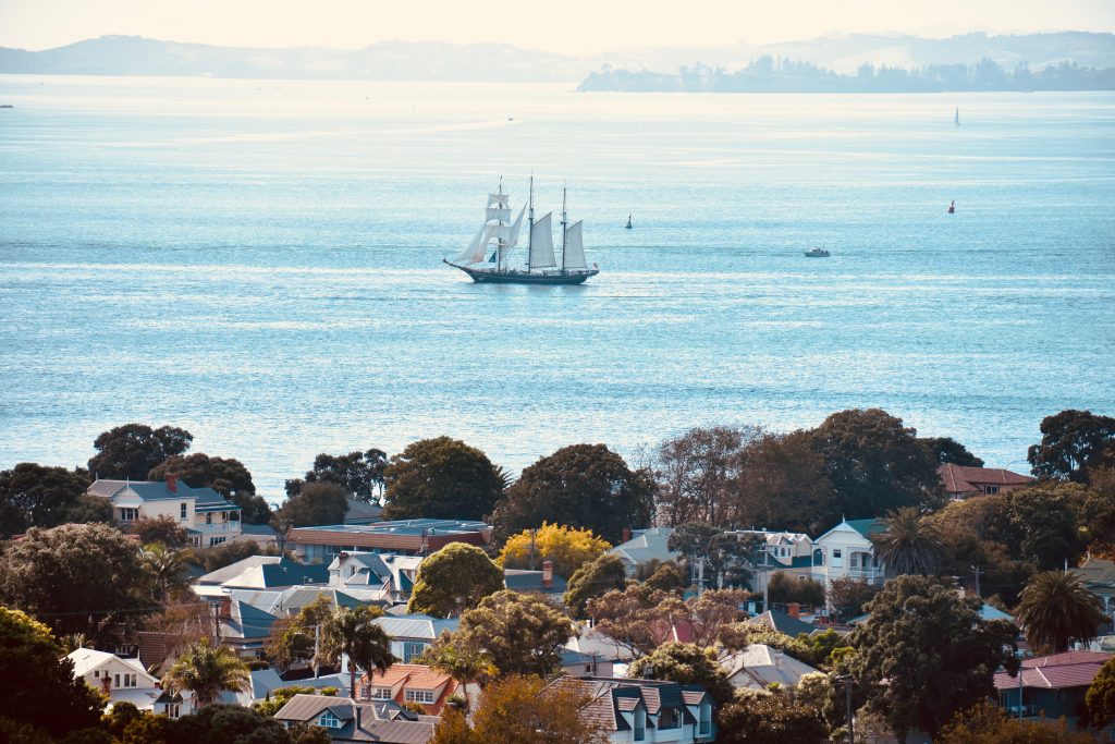 A view of a vintage sailing ship seen from a walking pathway on Devonport’s Victoria Hill is a treat for visitors who are walking New Zealand. (Image © Joyce McGreevy)