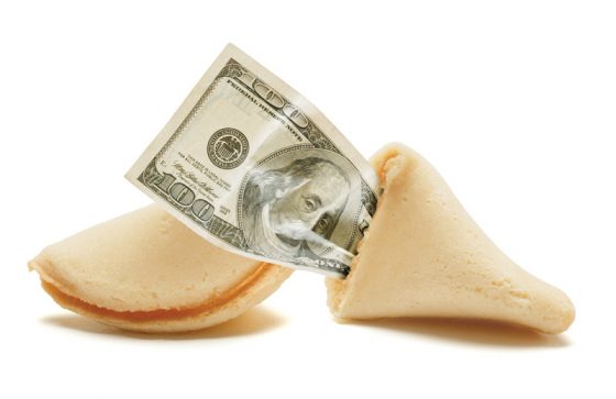 Fortune cookie with money inside, a new version of proverbs and sayings for fortune cookies. (Image © Photodisc.)