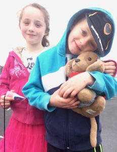 A toy canine travel mascot named Bedford, shown with Irish children, inspires his human travel buddy to see the world differently. (Image © Joyce McGreevy)