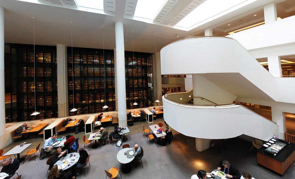 The interior of the British Library, with the smoked glass wall of the King's Library reflecting England's cultural heritage. 
