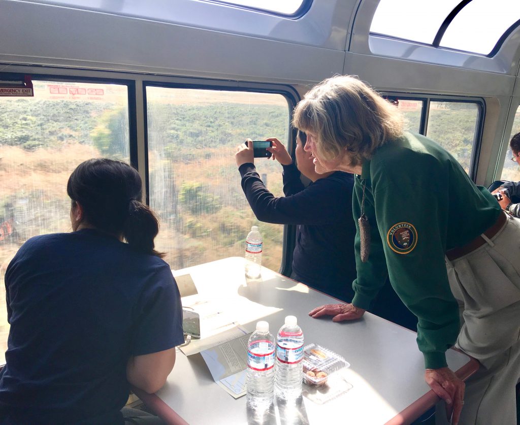 National Park Service guide Kathy Chalfant, seen here with passengers on the Coast Starlight, inspires aha moments with Trails & Rails tours. (Image © Joyce McGreevy)