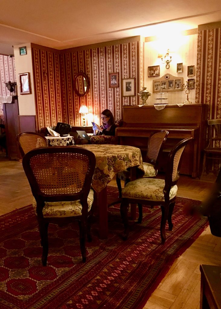 A woman writing at Zsivago Café inspires a travel tip: savor the café culture in Budapest, Hungary. Image © Joyce McGreevy