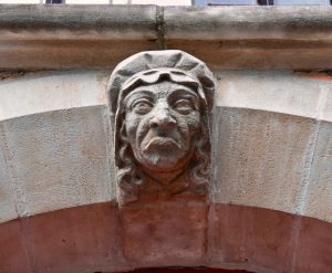 A carved stone head inspires thoughts about Flemish in Belgium, where being bilingual is just the beginning. (Image © Joyce McGreevy)