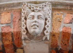 A carved stone head inspires thoughts about language in Belgium, where being bilingual is just the beginning. (Image © Joyce McGreevy)