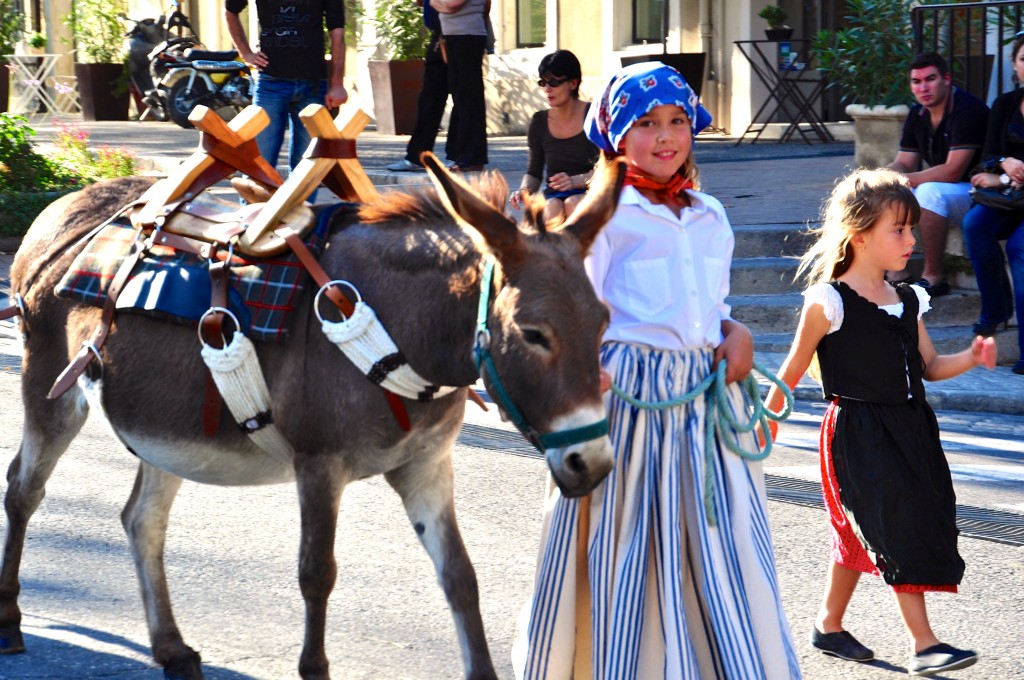 Girls & donkey in parade celebrating French cultural heritage and traditions