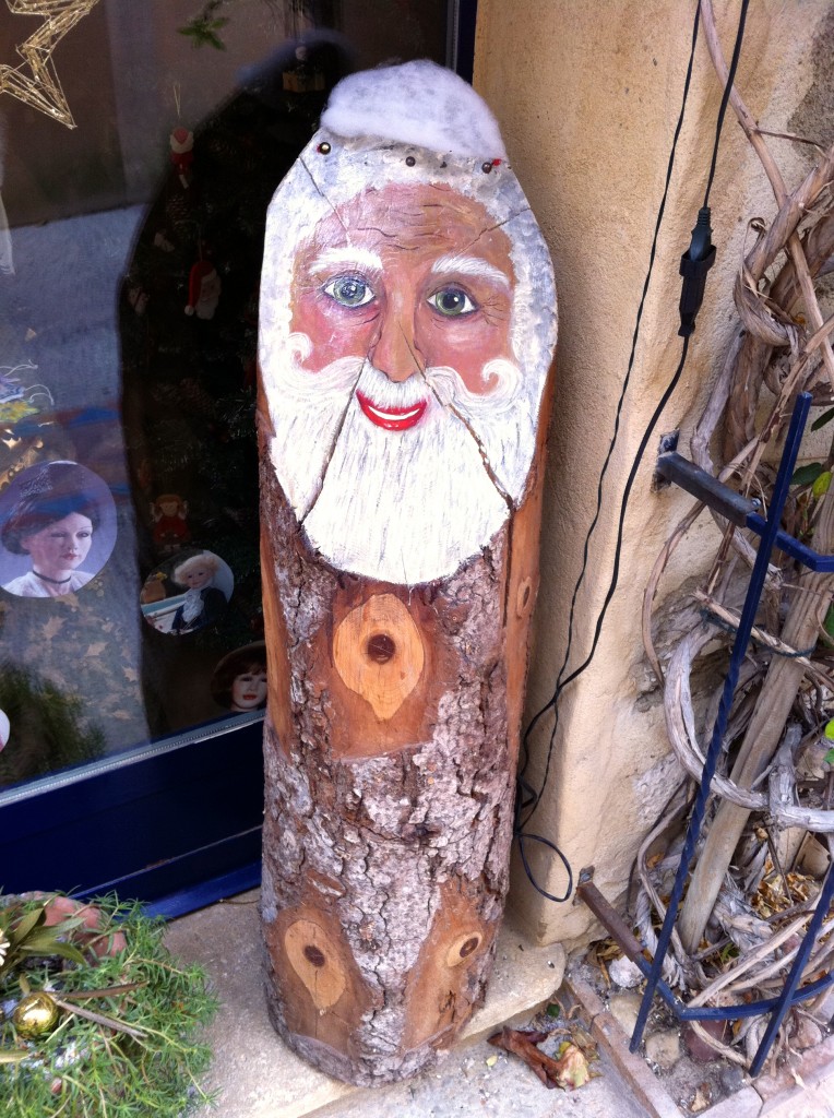 Wooden Pere Noel by a French doorway, showing Christmas traditions of different cultures