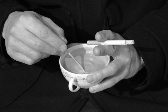 hands holding coffee and cigarette after a random act of kindness with a suspended coffee