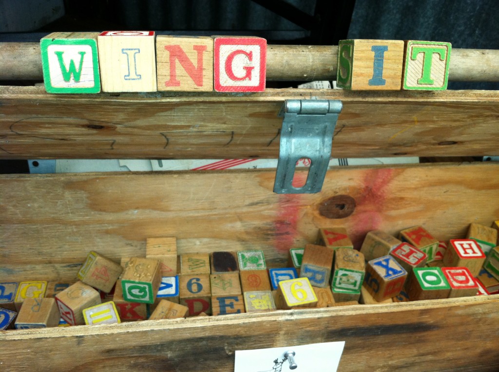 Blocks spelling "Wing It," showing the value of vagabond travel