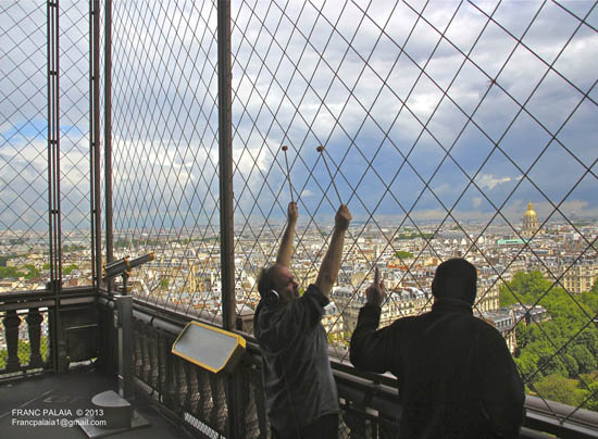 Joe Bertolozzi hammering with two arms, artistic expression on the Eiffel Tower.