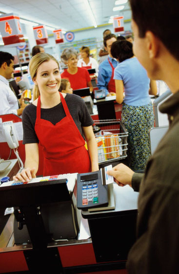 Clerk smiles at customer, a life lesson moment that could turn into a missed connection or carpe diem