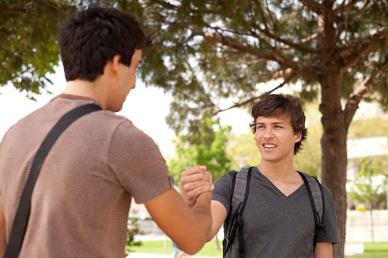 Two teens greeting each other to illustrate the meaning of "tartle," a Scottish word that should become a borrowed word and used across different cultures. (Image © Thinkstock)