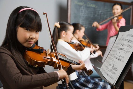 Children learning to play the violin, symbolizing the different musical scales across cultures