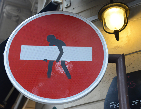 Man carrying bar on No Entry sign, artistic expression from a street artist (Image © Meredith Mullins)