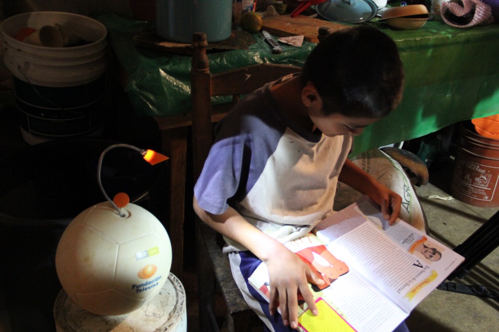 Boy studying after dark with the light of the SOCCKET, a creative solution for families in energy-deprived locations. Image © Uncharted Play Team.