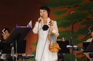 Kimiko Nakazawa with tsunami violin, illustrating cross-cultural contributions on the path to healing (Image courtesy of Classic for Japan Foundation)