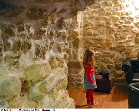 Girl plays with cat in a corner, living a happier life at the Cat Café in Paris (Photo © Meredith Mullins)