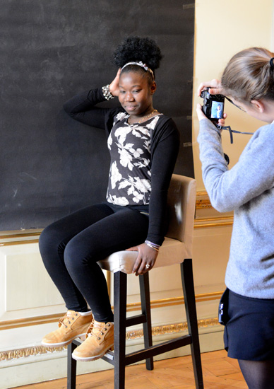 Black girl poses on chair for photographer, getting creative inspiration from Yousuf Karsh's 20th century heroes (Photo © Meredith Mullins)