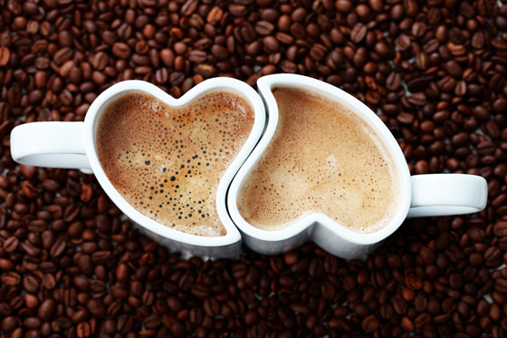Two steaming cups of coffee in heart-shaped cups, illustrating love quotes on how two people enjoy each other on Valentine's Day. (Image © Matka_Wariatka / iStock)