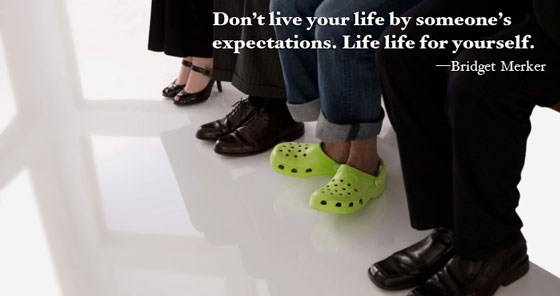 Legs of four people seated, one wearing bright green shoes and representing good advice on living life for yourself