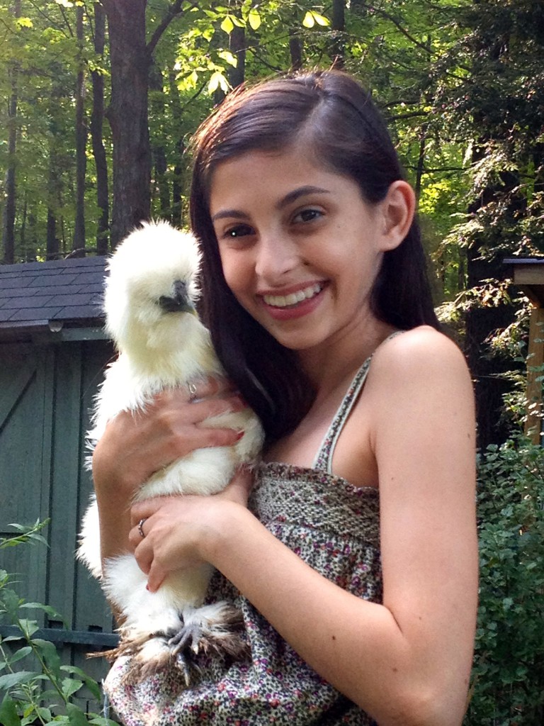 Girl holding a backyard chicken, a pet that can help you be happier. (Image © Jeff Corbin)