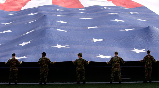 Airmen presenting a 100-yard by 50-yard flag at the Las Vegas Bowl, 2006, while the audience sings "The Star-Spangled Banner," an anthem personalized over time by a century's worth of creative thinking. (Image © Stocktrek Images)