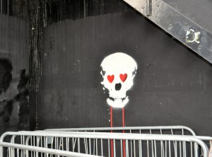 Head of a skeleton with red heart-shaped eyes done illegally in spray paint by a creative street artist. (Photo © Sheron Long)
