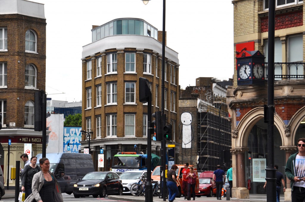 Large stick figure on a building at a busy Shoreditch intersection by creative street artist, Stik.  (Photo © Sheron Long)