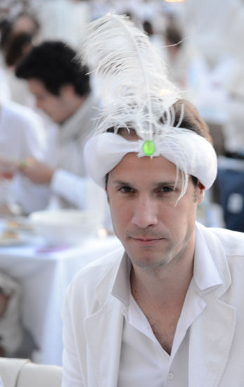 Man in white headgear at the Dîner en Blanc, a way to live life to the fullest (Photo © Meredith Mullins)