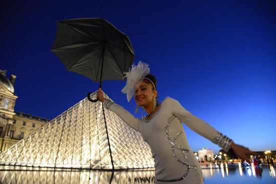 Woman in white in front of the Louvre, a guest at Diner en Blanc, the White Dinner, in Paris, France, a way of living life to the fullest (Photo © Meredith Mullins)