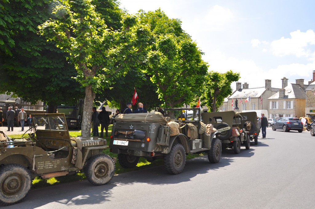 US military vehicles line up by the reconstruction of a WWII military camp where people commemorate the 70th Anniversary of D-Day as one of the greatest moments in history. (Image © Sheron Long)