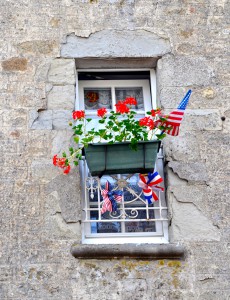 Window of a Normandy house decorated with flags and ribbons for the 70th Anniversary of D-Day, one of the great moments in history. (Image © Sheron Long)