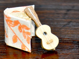 Miniature book from paper and tiny guitar from wood are examples of the artisanal crafts of Mexican culture. (Image © Sheron Long)