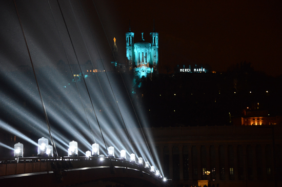 Bridge with lighting installation with church in the background, showing the art of light for Fête des Lumières in Lyon (Photo © Meredith Mullins)