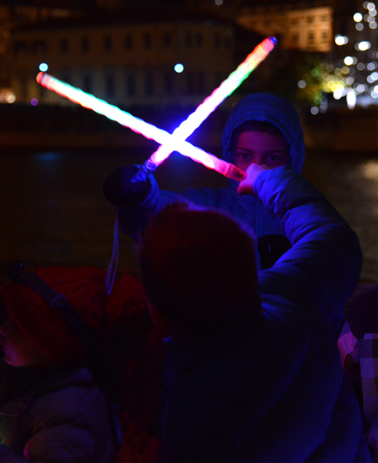 Children with light swords at the Fête des Lumières in Lyon, a festival celebrating the art of light with light installations (Photograph © Meredith Mullins)