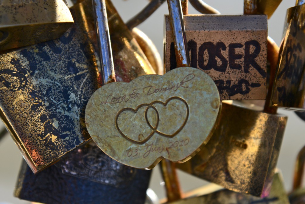 Gold love lock with two hearts, showing romance in Paris and answering the question "Can Love Conquer All?" (Photo © Meredith Mullins)