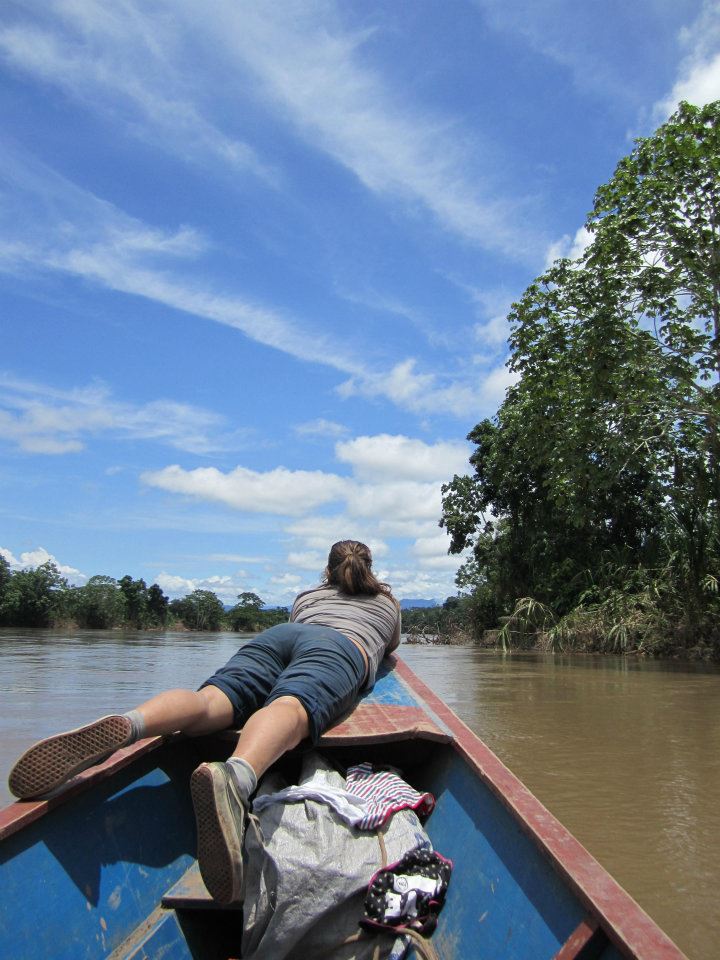 A girl looking out from the edge of a wooden boat on a river in the Amazon, illustrating why study abroad has a lasting effect. (Image © Rydell Welch) 