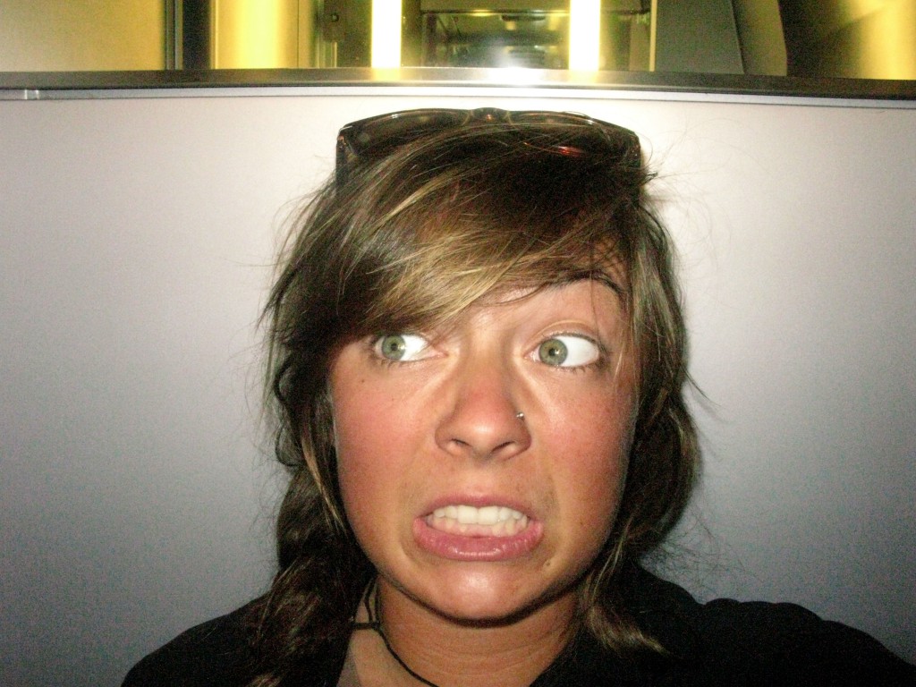 Girl in train bathroom with scared expression, showing the travel ninja's journey after losing everything and gaining insight for her travel tips. (Image © Eva Boynton)