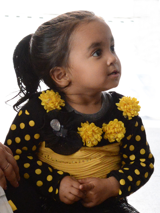 Girl with gold flowers in Old Delhi, cultural encounters in Northern India that provide travel inspiration. (Image © Meredith Mullins)