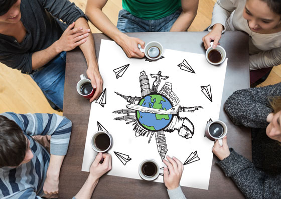 A circle of people's hands holding coffee on a table with an image of the world in the middle, showing the connections formed by breaking the language barrier. (Image © Wavebreak Media/Thinkstock )