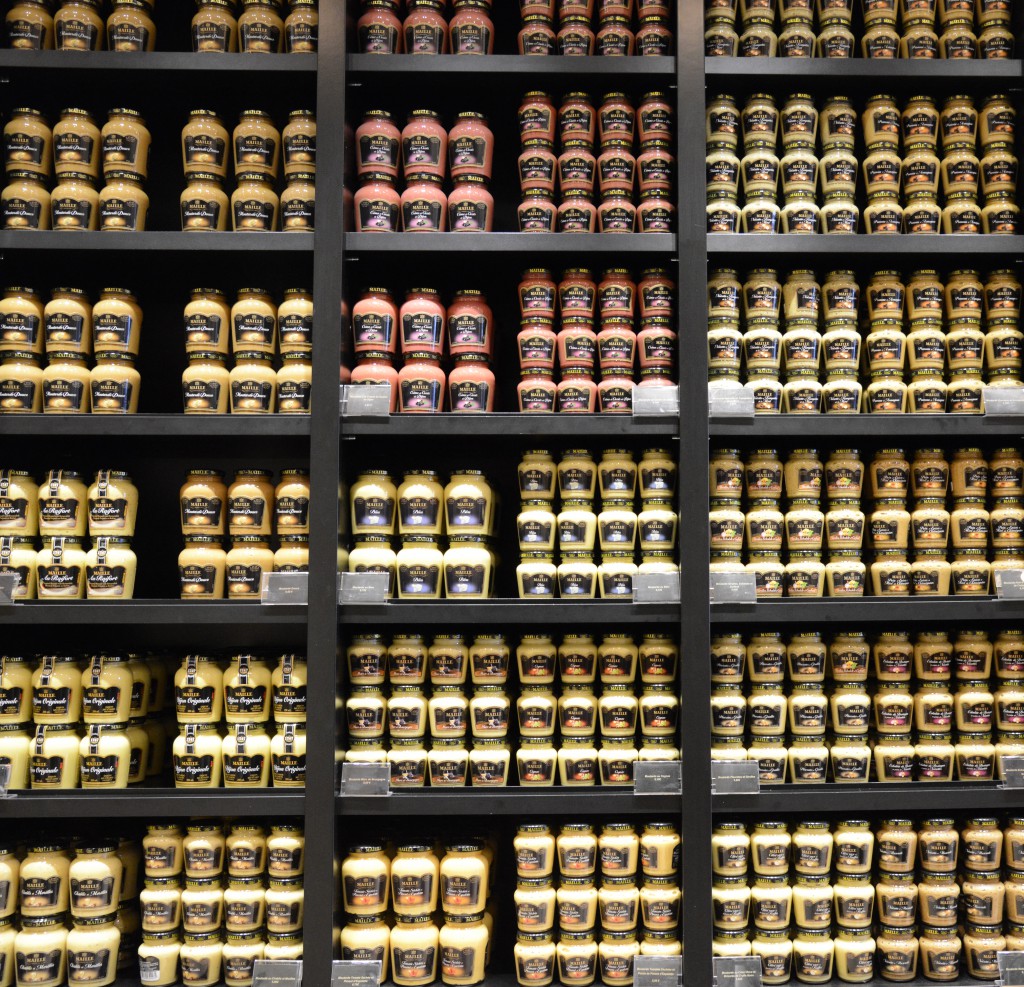 Wall of mustard at Maille, showing the focus on food in French sayings. (Image © Meredith Mullins)