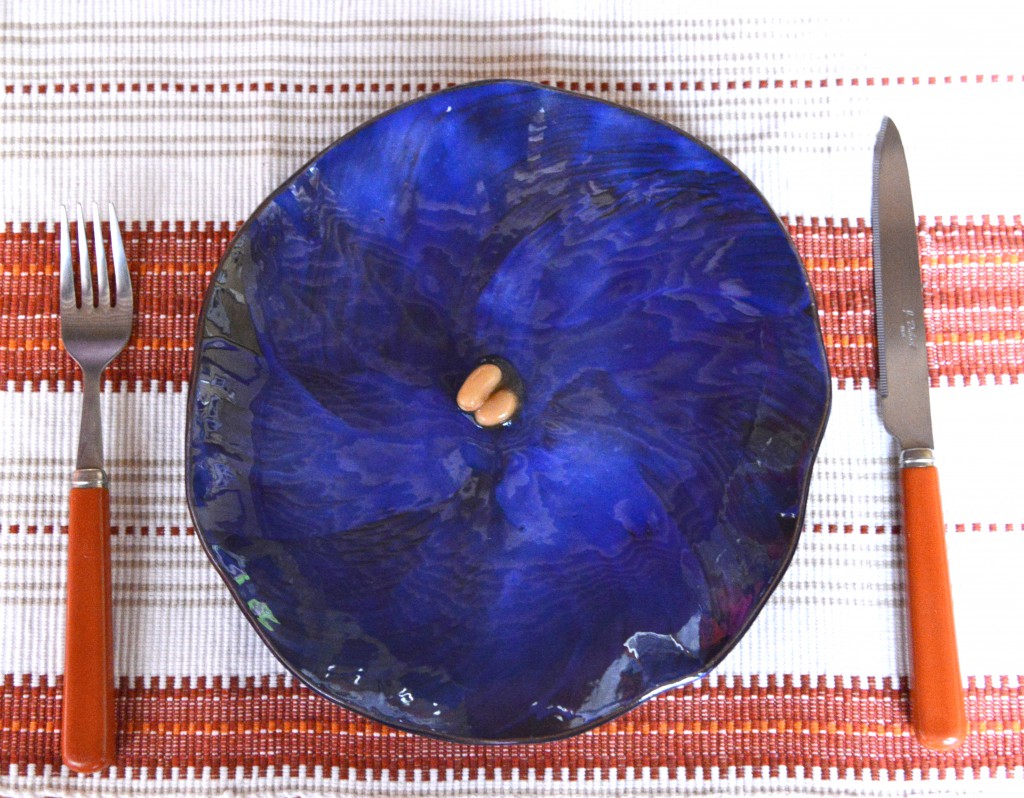 A few beans on a blue plate, showing the focus on food of French sayings. (Image © Meredith Mullins)