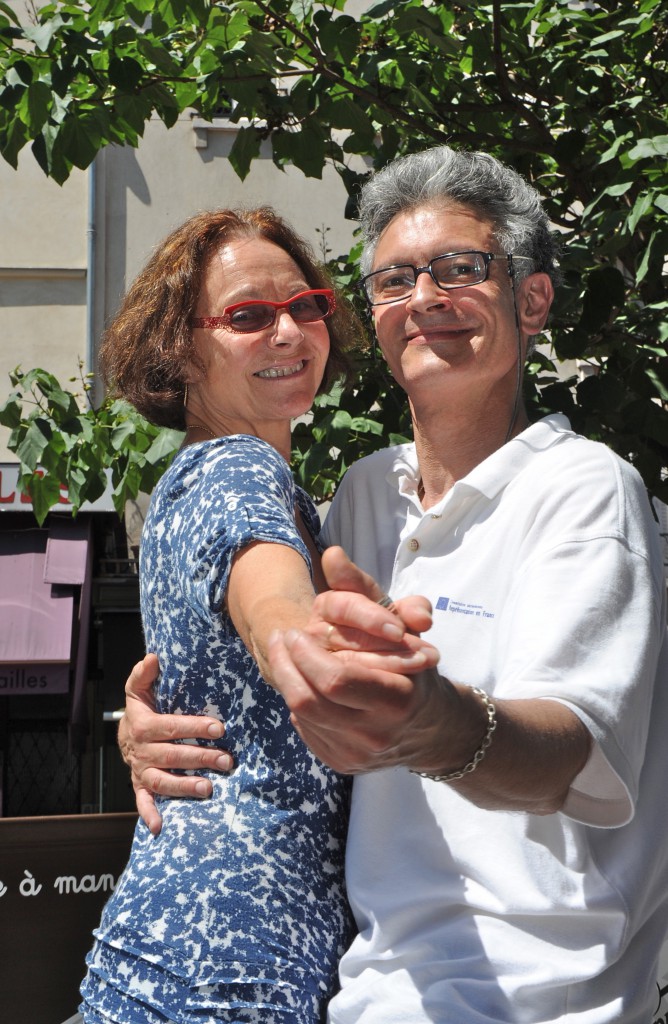 Couple dancing toward the camera at le petit bal musette on the rue Mouffetard, showing the universal language of music. (Image © Meredith Mullins).