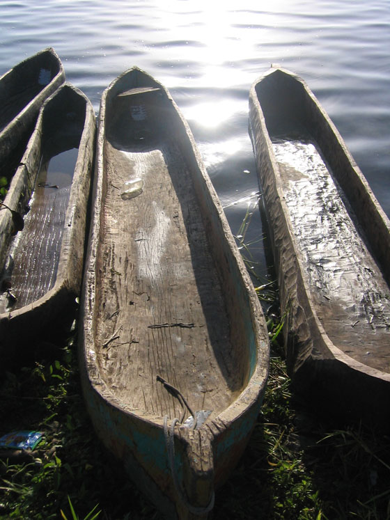 Three wooden canoes on a body of water, providing one of endless experiences whose memory can spark the post-vacation blues.  (Image © frankdennerlein / Thinkstock)