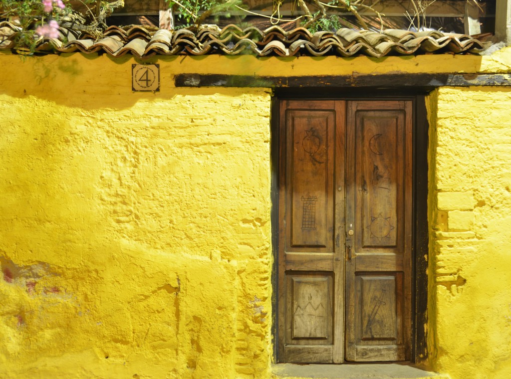 Off-centered door in yellow stucco wall, a colorful memory recalled during post-vacation blues.  (Image © Scott Kafer)