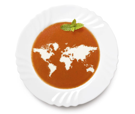 The continents depicted in cream in a bowl of tomato soup, illustrating that people at lunch around the world have different cultural do's and taboos. (Image © eyegelb / iStock)